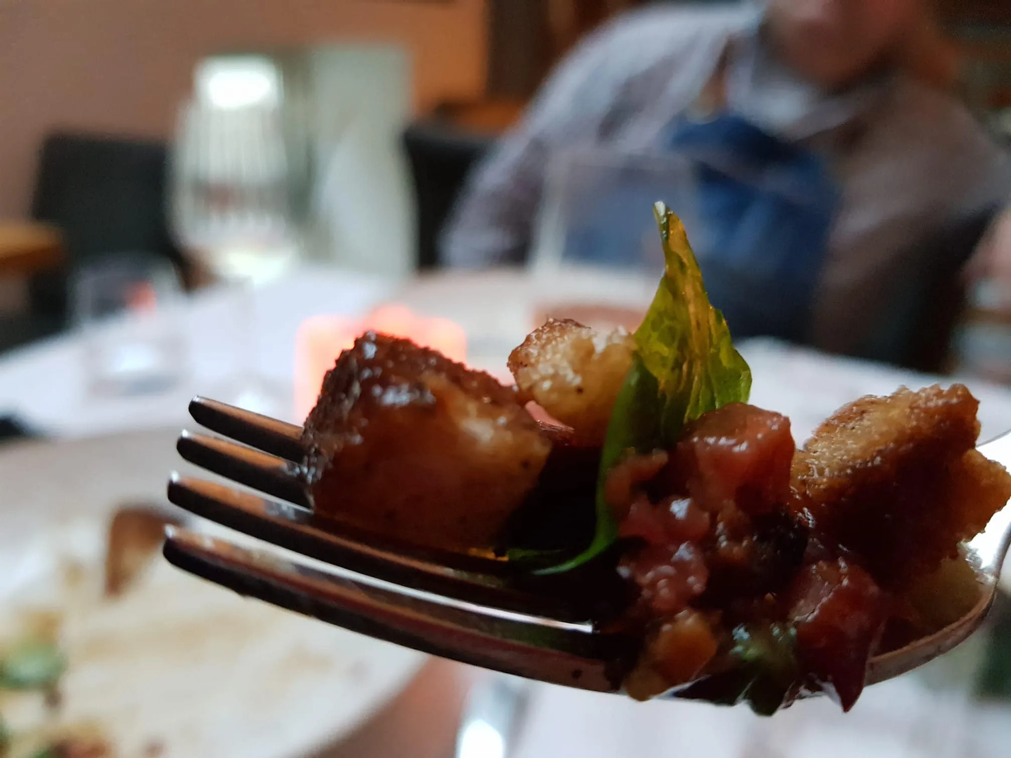 Festland – Restaurant & Vinothek – Nahaufnahme eines kleinen Häppchens, wahrscheinlich einer Vorspeise, auf einer Gabel.